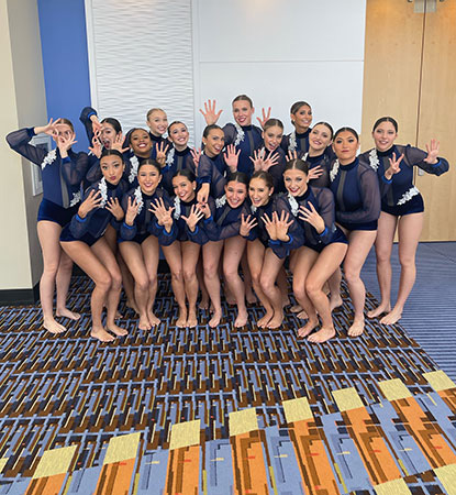 A group of dancers waving to the camera